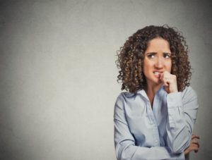 Stressed woman biting her nails should see her Reno dentist